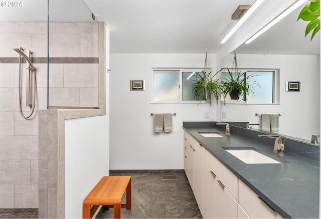 bathroom featuring double vanity, walk in shower, plenty of natural light, and a sink