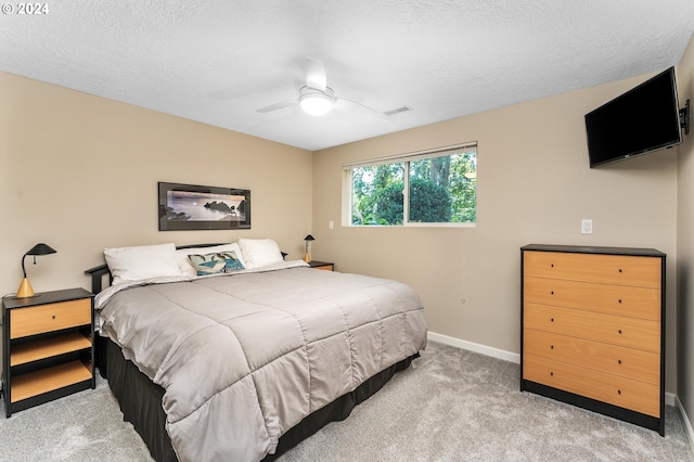 carpeted bedroom featuring a ceiling fan, visible vents, a textured ceiling, and baseboards