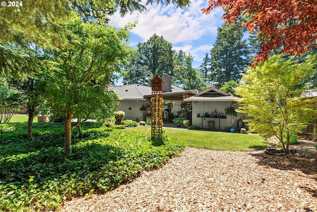 rear view of property featuring a lawn and a chimney