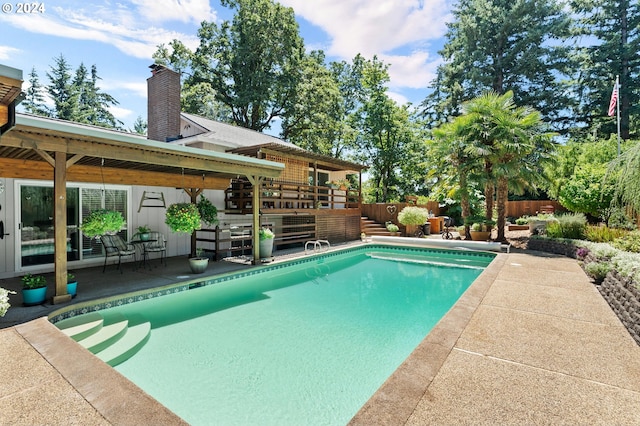 view of swimming pool featuring a fenced in pool, a patio area, fence, and a deck