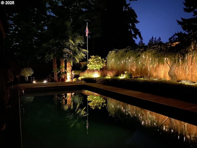 pool at twilight featuring a fenced in pool