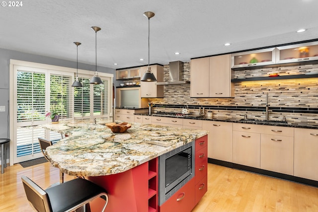 kitchen with open shelves, light wood-style flooring, decorative backsplash, appliances with stainless steel finishes, and wall chimney exhaust hood