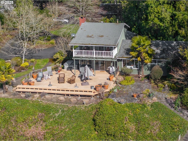 rear view of house featuring outdoor dining area, a yard, and a deck