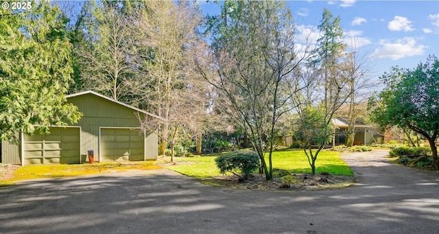 view of front of property with an outbuilding, a garage, and a front lawn