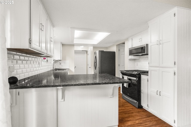 6516 SW Locust St, Portland, OR 97223 - kitchen featuring stainless steel appliances, a peninsula, and white cabinetry