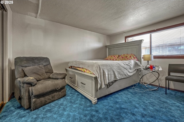 bedroom featuring dark carpet and a textured ceiling