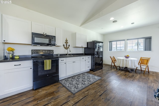 kitchen featuring dark countertops, dark wood-style flooring, black appliances, and a sink