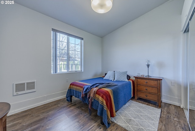 bedroom with baseboards, wood finished floors, and vaulted ceiling