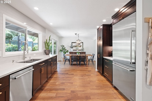 1437 Greentree Cir, Lake Oswego, OR 97034 - kitchen featuring appliances with stainless steel finishes, a sink, light wood-type flooring, recessed lighting, and light countertops