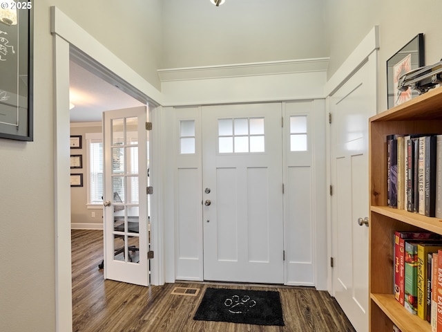 foyer with dark wood-type flooring and visible vents