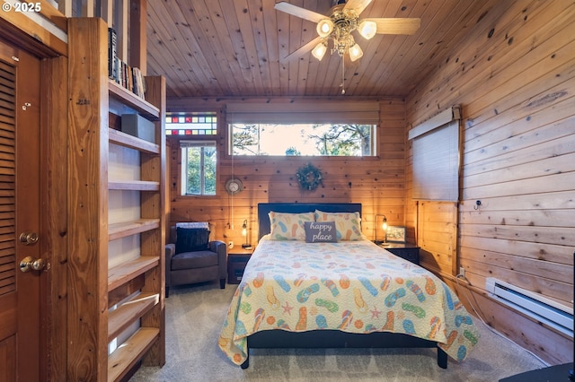 bedroom with wooden walls, wood ceiling, a baseboard heating unit, and carpet