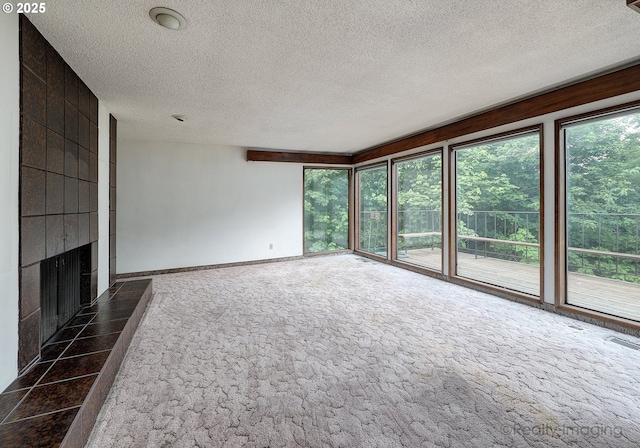6902 SW 2nd Ave, Portland, OR 97219 - unfurnished living room with a fireplace, dark carpet, baseboards, and a textured ceiling