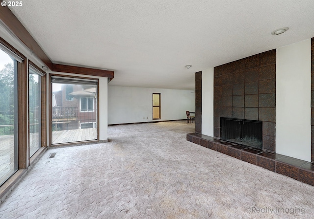 6902 SW 2nd Ave, Portland, OR 97219 - unfurnished living room featuring carpet flooring, a tile fireplace, and a textured ceiling