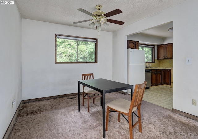 6902 SW 2nd Ave, Portland, OR 97219 - dining room with healthy amount of natural light, light colored carpet, a ceiling fan, a textured ceiling, and baseboards