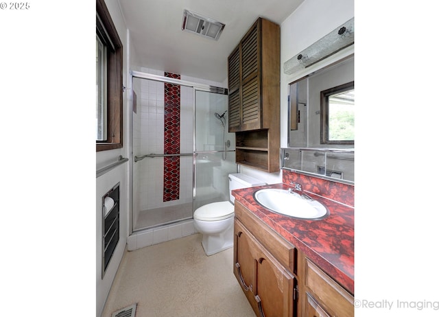 bathroom featuring vanity, an enclosed shower, and toilet