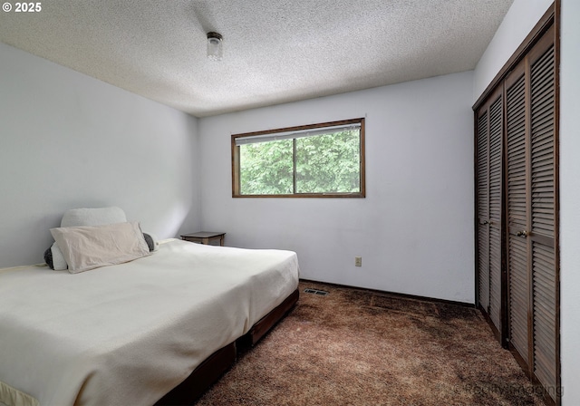 carpeted bedroom featuring a closet and a textured ceiling