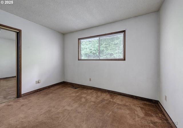 carpeted empty room with a textured ceiling