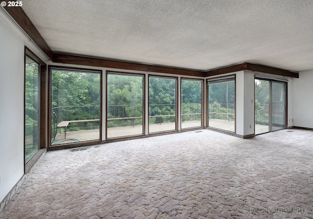 unfurnished living room featuring carpet flooring, a tile fireplace, and a textured ceiling