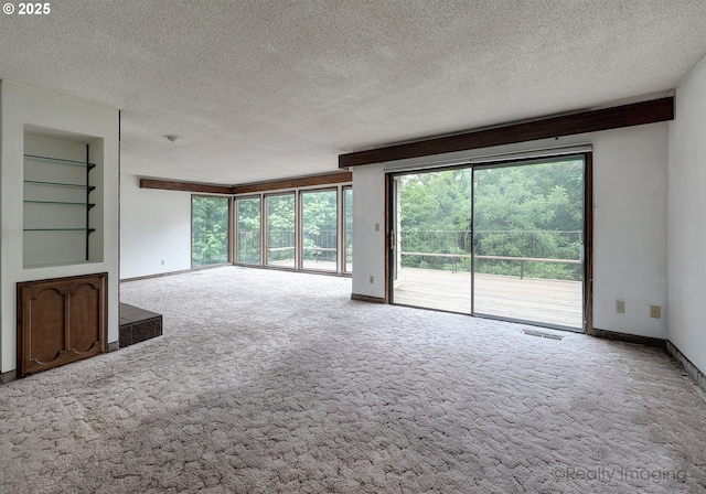 unfurnished living room with built in features, a textured ceiling, and carpet