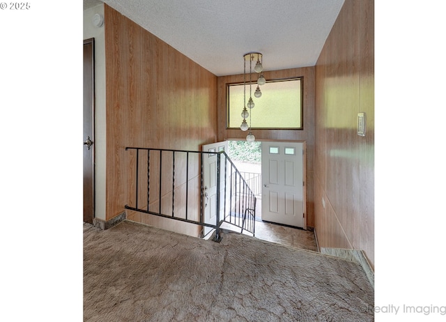 6902 SW 2nd Ave, Portland, OR 97219 - entryway featuring wooden walls, carpet, and a textured ceiling