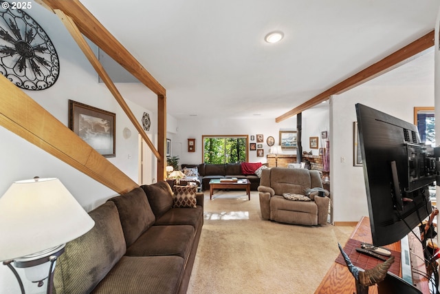 carpeted living room featuring beam ceiling