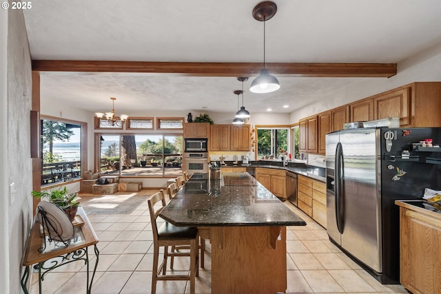 kitchen featuring light tile patterned flooring, a kitchen island, hanging light fixtures, stainless steel appliances, and beam ceiling