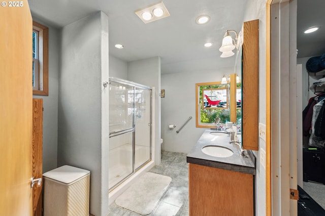 bathroom with vanity, toilet, and a shower with shower door