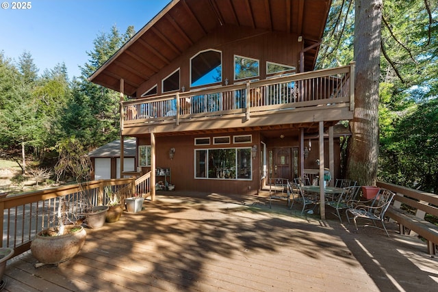 wooden terrace featuring an outbuilding and a garage