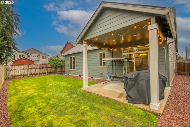 rear view of property with crawl space, a lawn, a fenced backyard, and a patio area