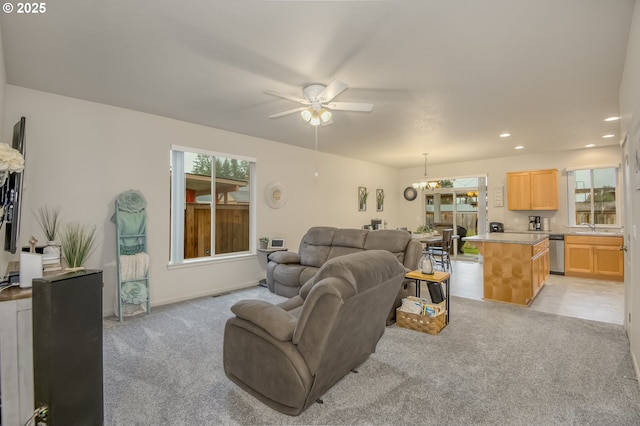 living room with light carpet, recessed lighting, ceiling fan with notable chandelier, and baseboards