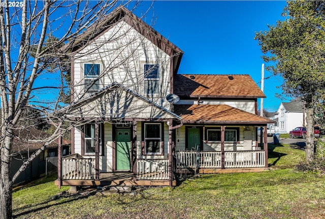 back of property with a lawn and covered porch