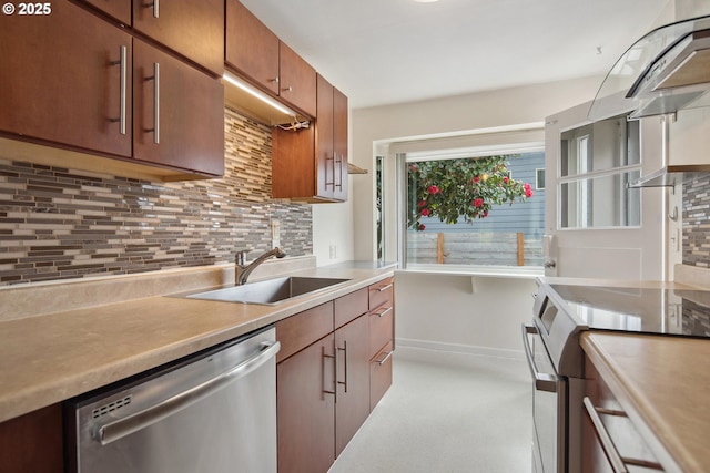 kitchen with decorative backsplash, baseboards, a sink, and appliances with stainless steel finishes