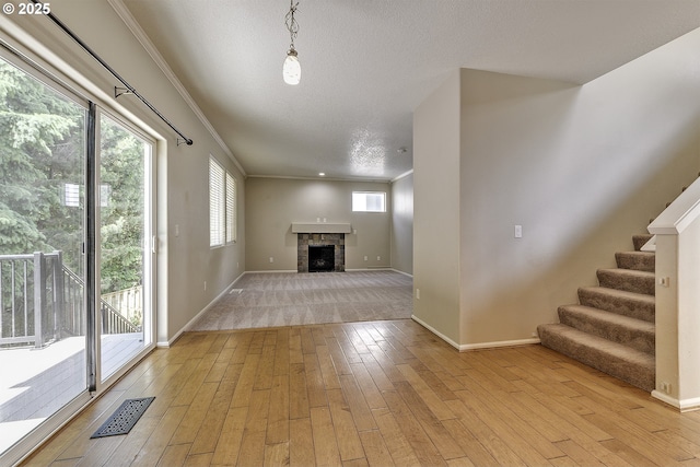 20074 SW Squire Dr, Beaverton, OR 97007 - unfurnished living room featuring light wood finished floors, stairs, a fireplace, and ornamental molding