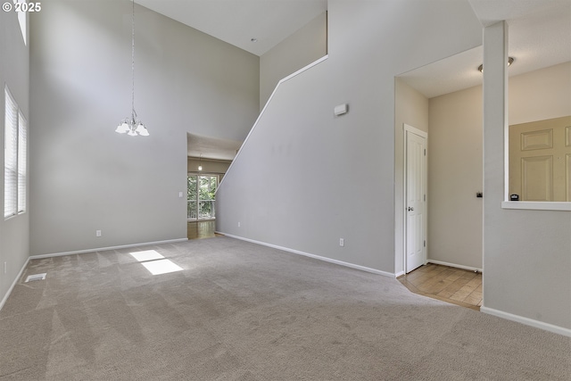 20074 SW Squire Dr, Beaverton, OR 97007 - unfurnished living room with a chandelier, carpet, and a towering ceiling