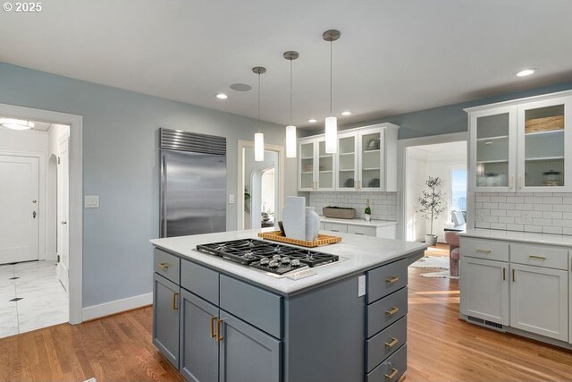 kitchen with decorative backsplash, wine cooler, white cabinetry, a sink, and appliances with stainless steel finishes
