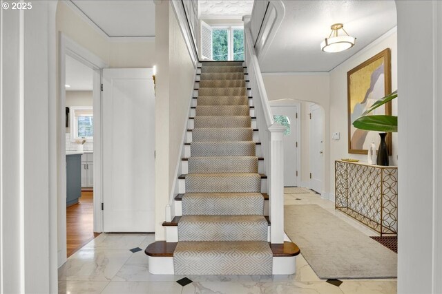 living room with crown molding, arched walkways, visible vents, and wood finished floors