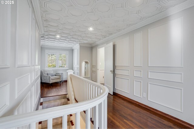 bathroom with a tub, toilet, ornamental molding, and wood finished floors