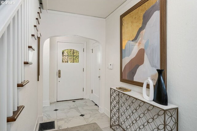 entryway with arched walkways, baseboards, visible vents, and marble finish floor