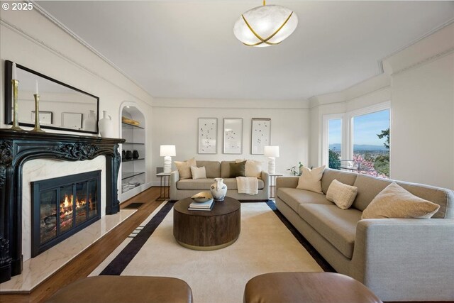 living area featuring baseboards, visible vents, ornamental molding, and wood finished floors