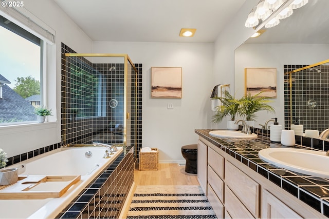 11069 SW Eschman Way, Tigard, OR 97223 - bathroom featuring a bath, a stall shower, double vanity, toilet, and wood finished floors