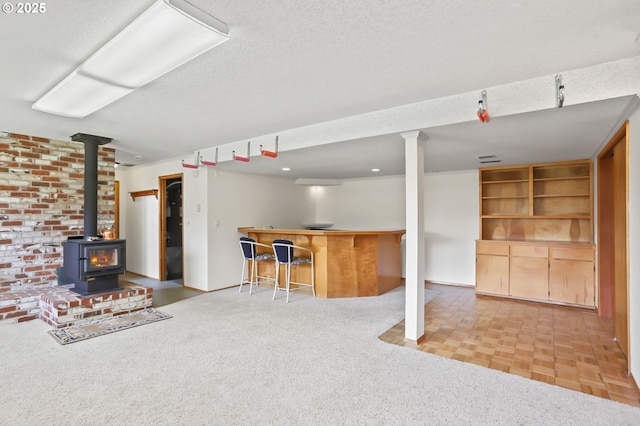 2335 5th St, Columbia City, OR 97018 - unfurnished living room with a dry bar, a wood stove, and a textured ceiling