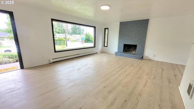 437 SE 154th Ave, Portland, OR 97233 - unfurnished living room with a baseboard radiator, wood finished floors, a fireplace, and a textured ceiling