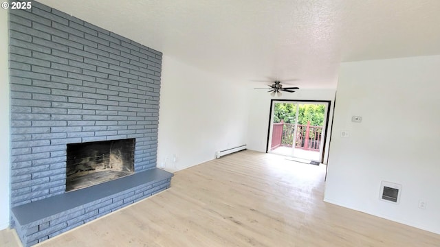 437 SE 154th Ave, Portland, OR 97233 - unfurnished living room with wood finished floors, a baseboard heating unit, a fireplace, a textured ceiling, and a ceiling fan