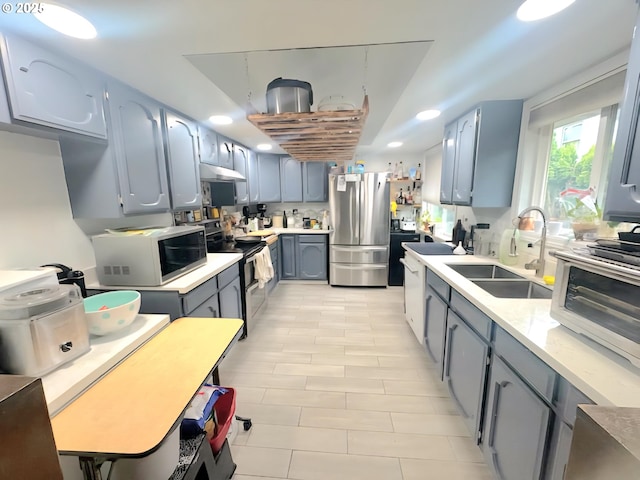 437 SE 154th Ave, Portland, OR 97233 - kitchen featuring stainless steel appliances, under cabinet range hood, a sink, light countertops, and gray cabinetry