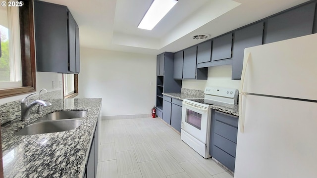 437 SE 154th Ave, Portland, OR 97233 - kitchen with white appliances, a raised ceiling, dark stone countertops, and a sink