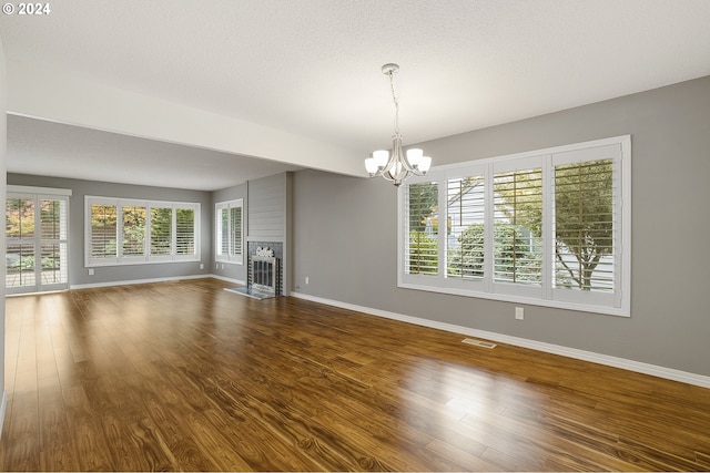 8070 SW Fairway Dr, Wilsonville, OR 97070 - unfurnished living room with a chandelier, plenty of natural light, and dark wood-style floors