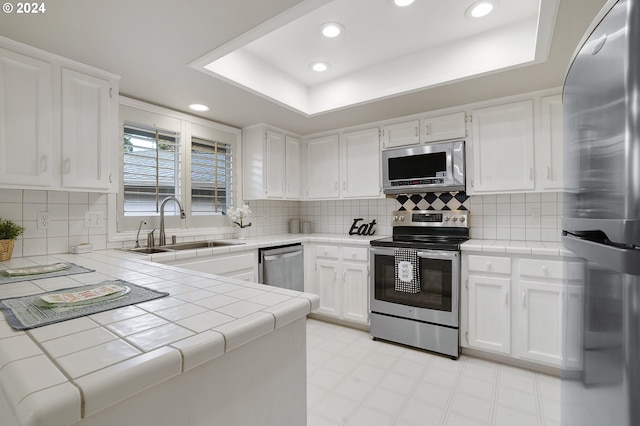8070 SW Fairway Dr, Wilsonville, OR 97070 - kitchen featuring stainless steel appliances, tile counters, light floors, white cabinets, and recessed lighting