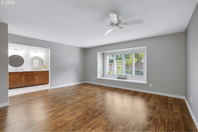 8070 SW Fairway Dr, Wilsonville, OR 97070 - unfurnished living room featuring a textured ceiling, light wood-style floors, ceiling fan, and baseboards