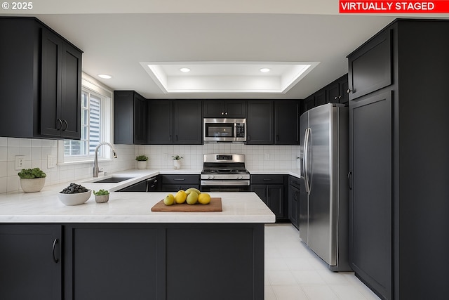 8070 SW Fairway Dr, Wilsonville, OR 97070 - kitchen featuring appliances with stainless steel finishes, a raised ceiling, a peninsula, tasteful backsplash, and recessed lighting