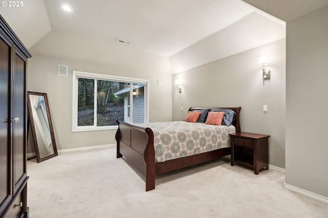 bedroom with light colored carpet, lofted ceiling, and baseboards